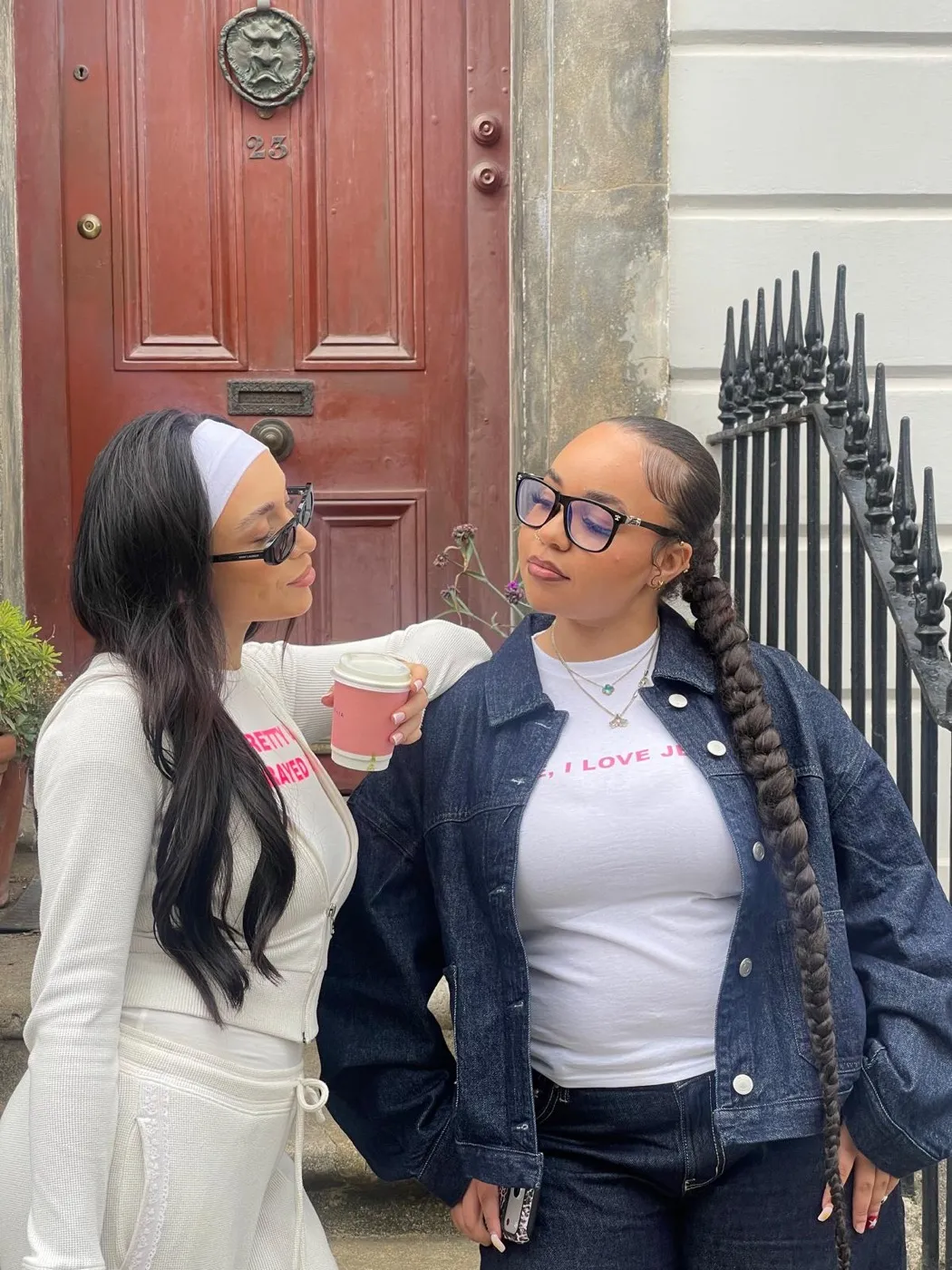 Two members outside a red door
